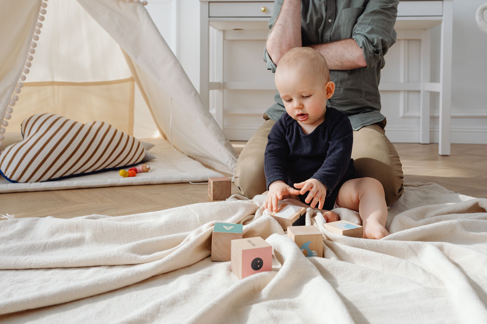 Cute baby playing with colorful wooden blocks in a cozy indoor setting, enjoying a playful afternoon.