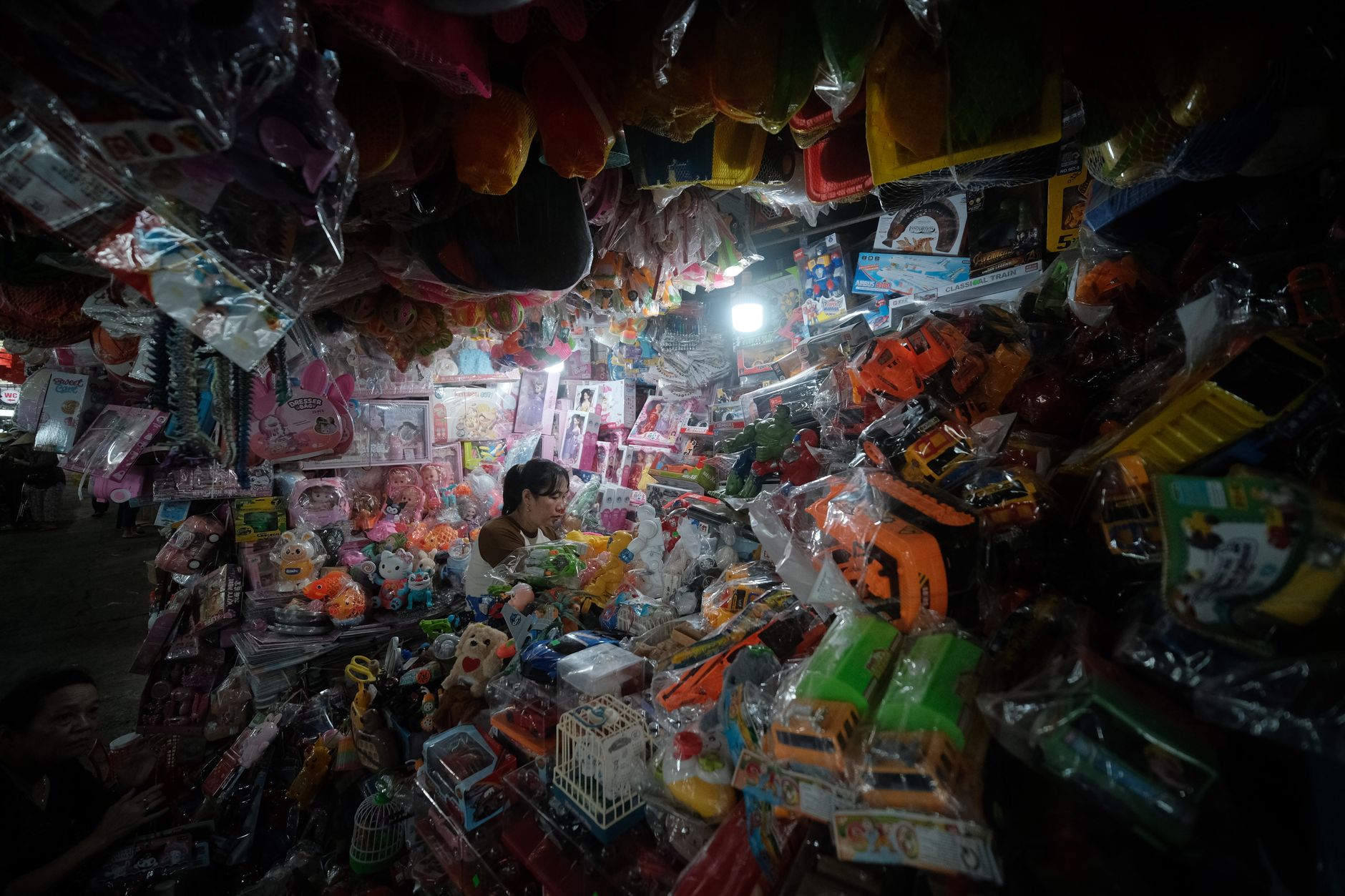 A bustling indoor toy shop filled with colorful toys and figures, showcasing a lively shopping atmosphere.