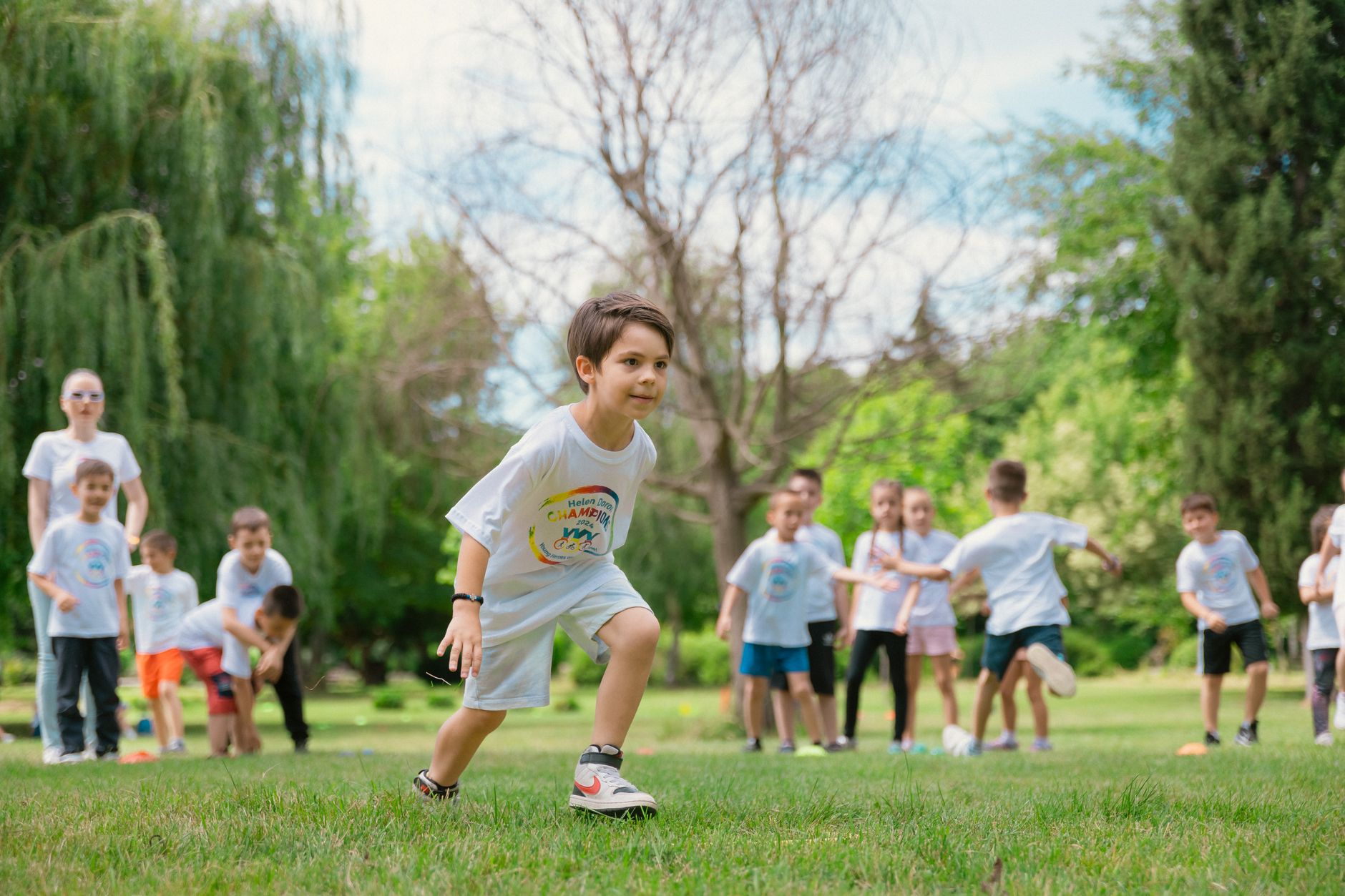 Group of children enjoying outdoor playtime in a green park during summer.