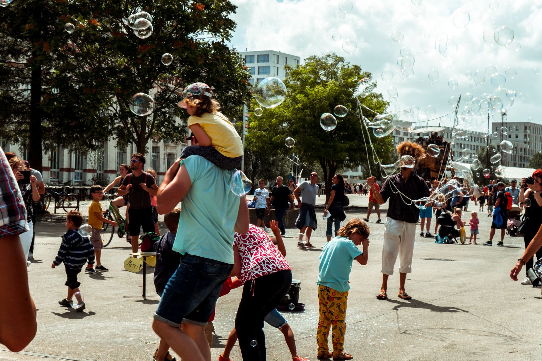 Children and adults enjoying bubbles at a street festival in Nantes, France.