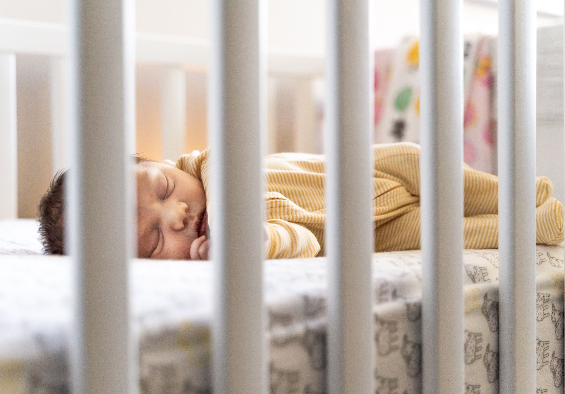A serene image of a baby sleeping peacefully in a crib, capturing warmth and tranquility.