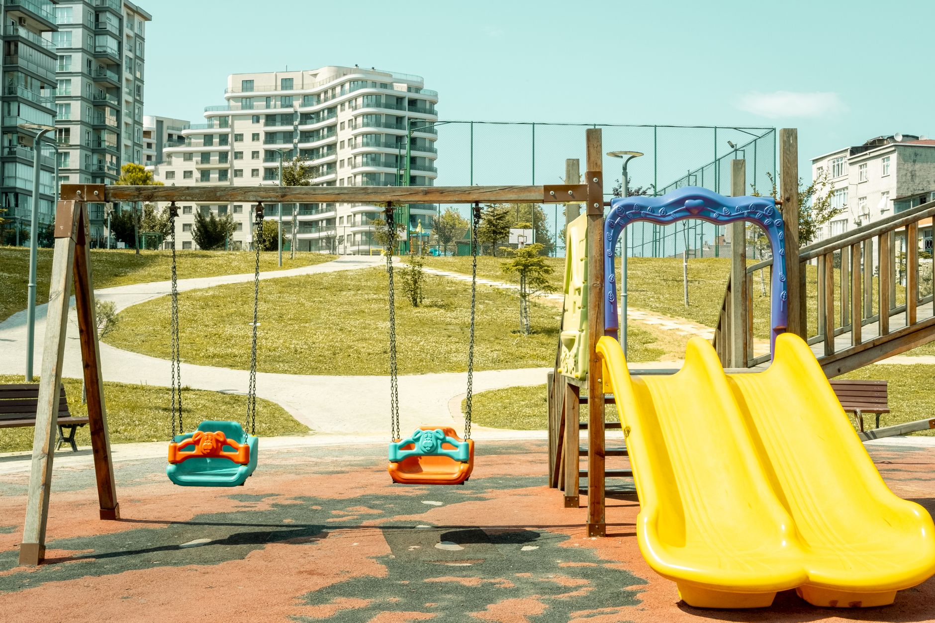 Colorful playground with swings and slide, perfect for outdoor fun and leisure.