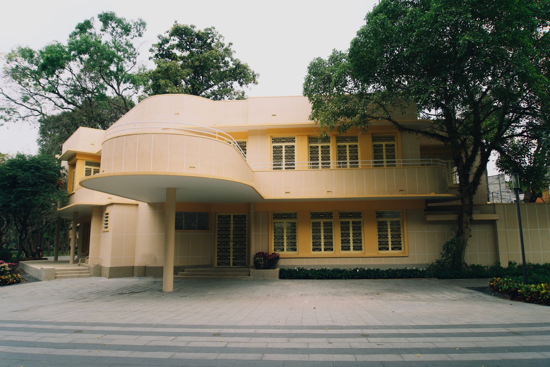 A stunning example of modernist architecture surrounded by lush greenery, captured in soft daylight.