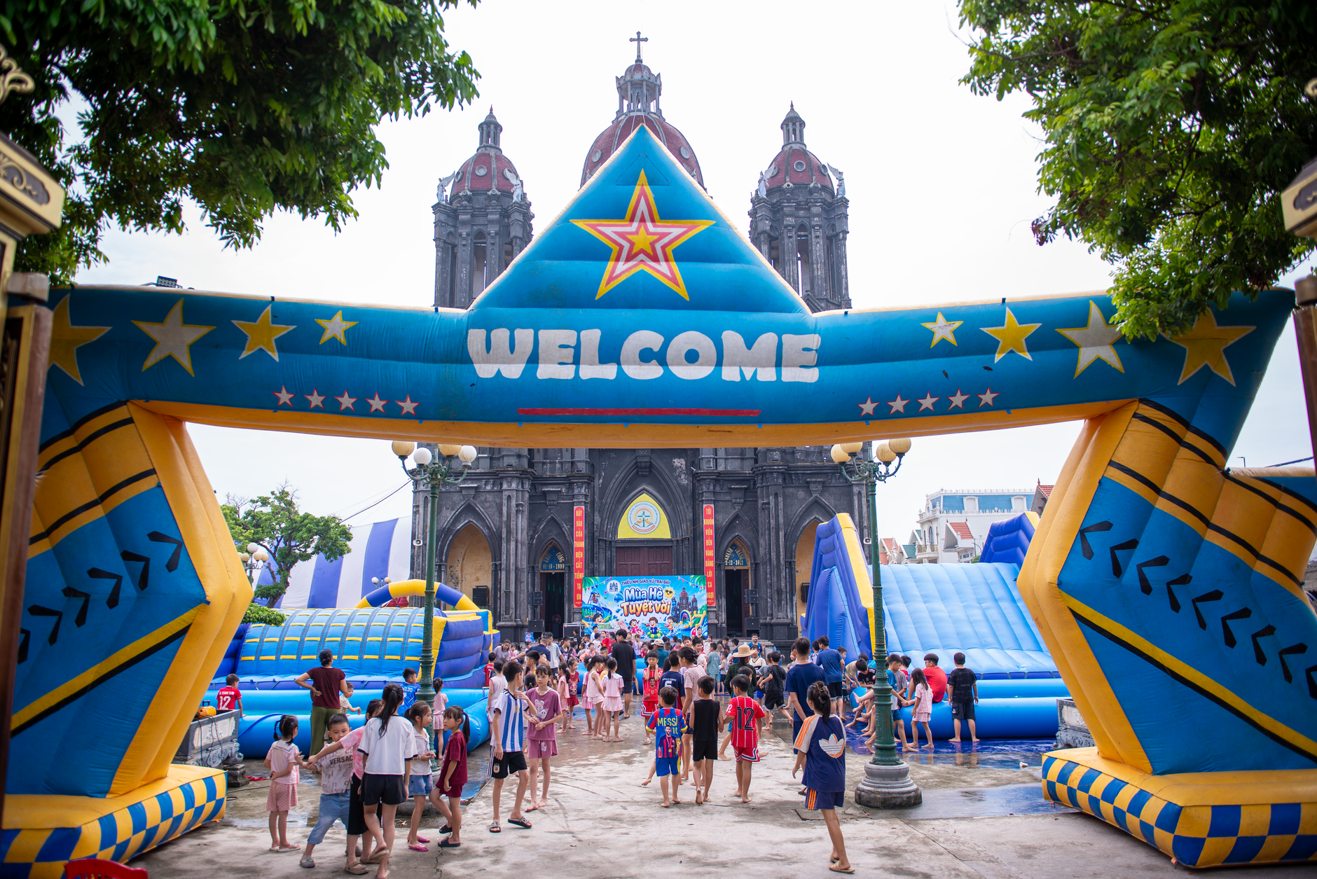 Colorful inflatable entrance welcomes crowd at festive outdoor event.