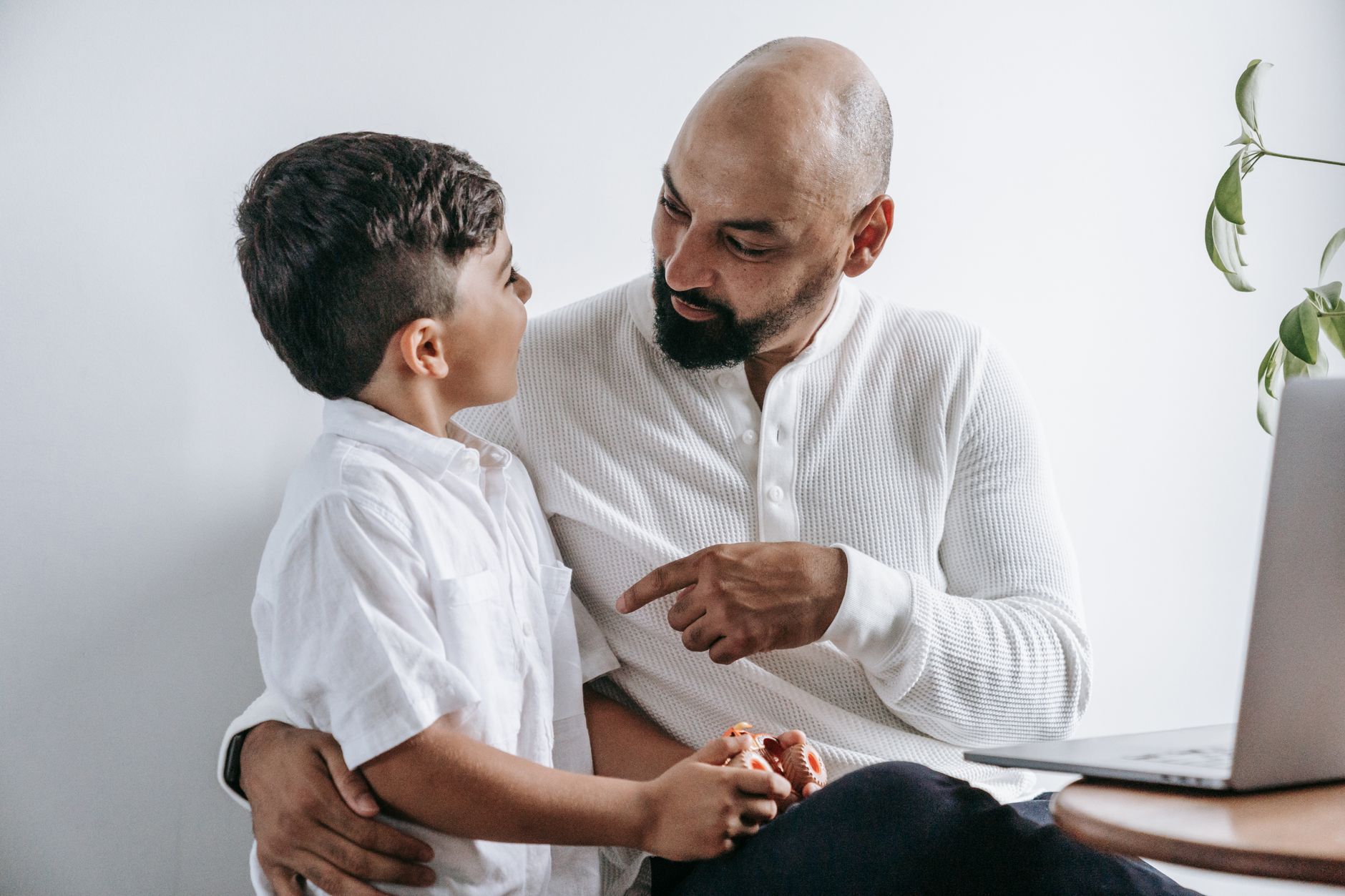 A touching scene of a father and son engaging in a deep conversation at home.